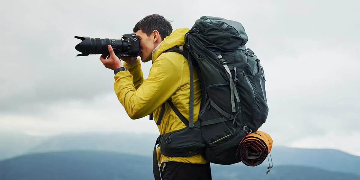 A passionate photographer is outdoors, equipped with a top-notch camera for bird photography.